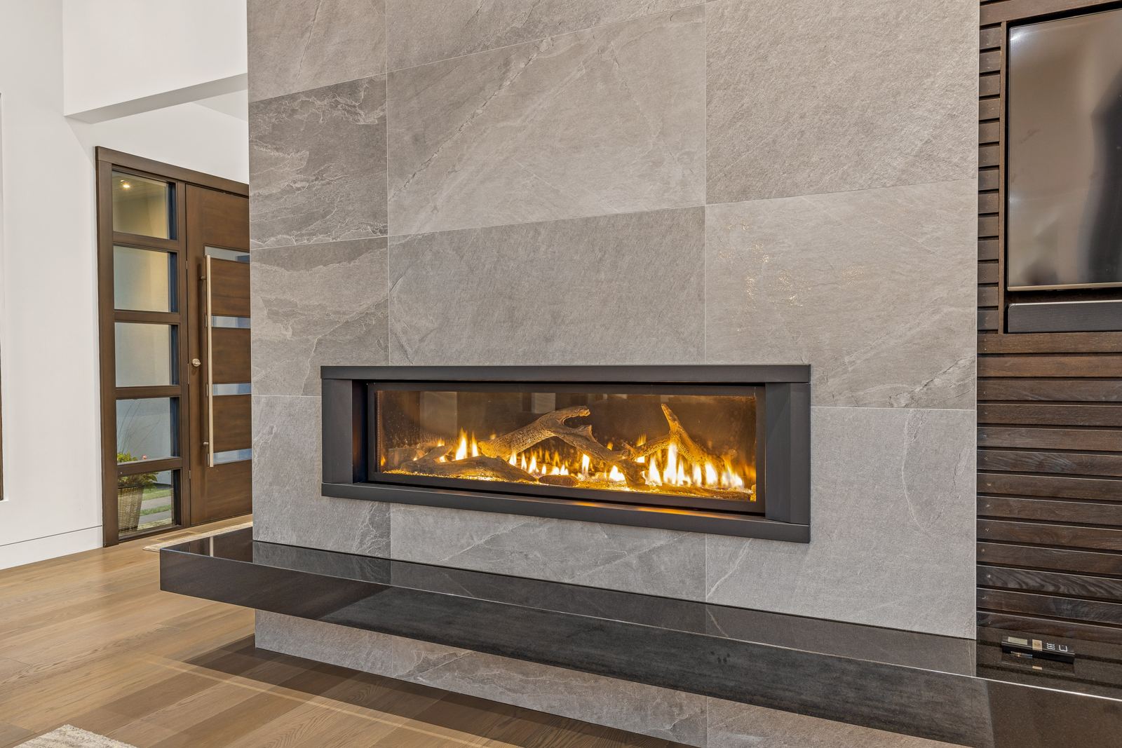 Linear fireplace set in a porcelain wall at dusk