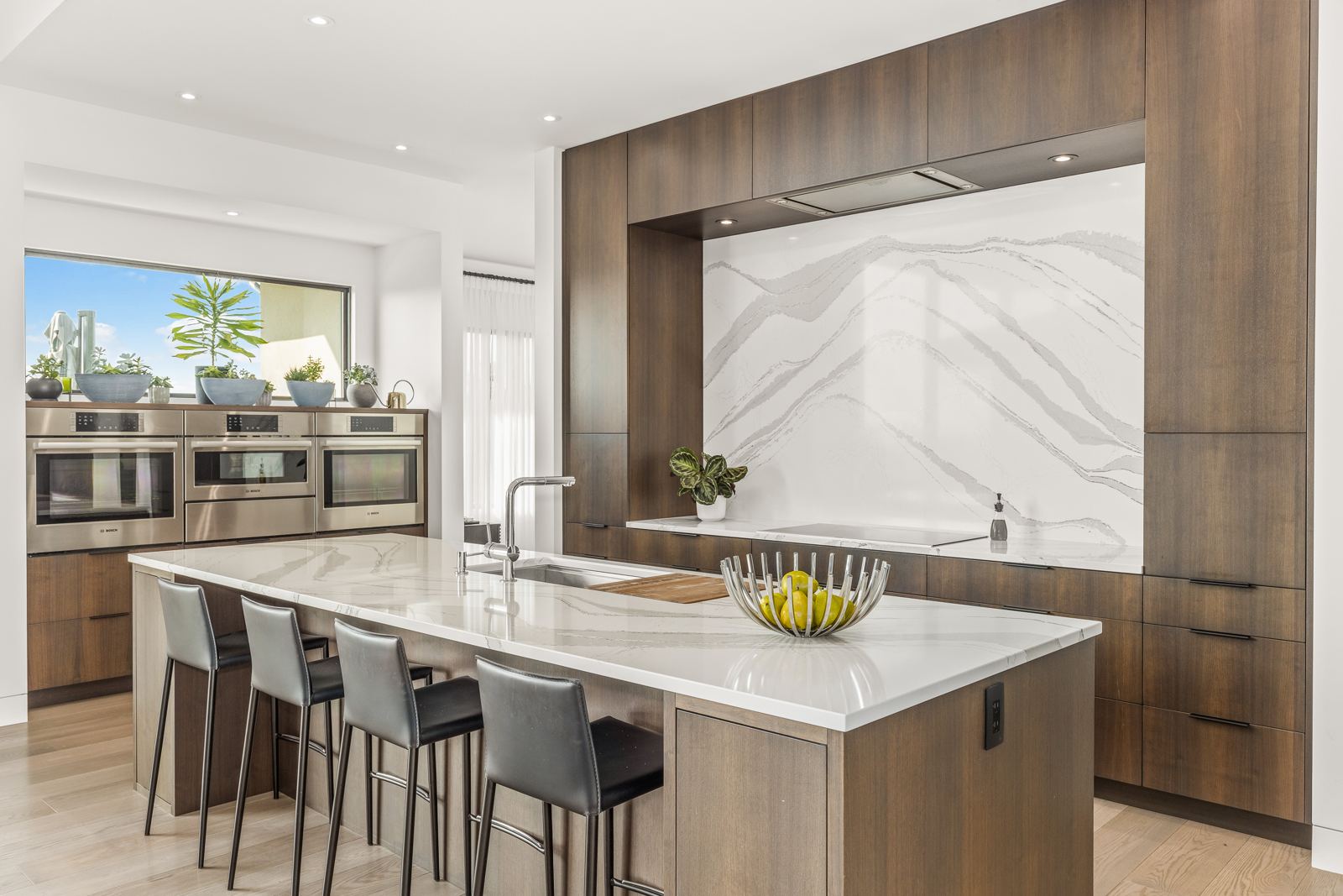 Kitchen with a waterfall island and walnut cabinetry